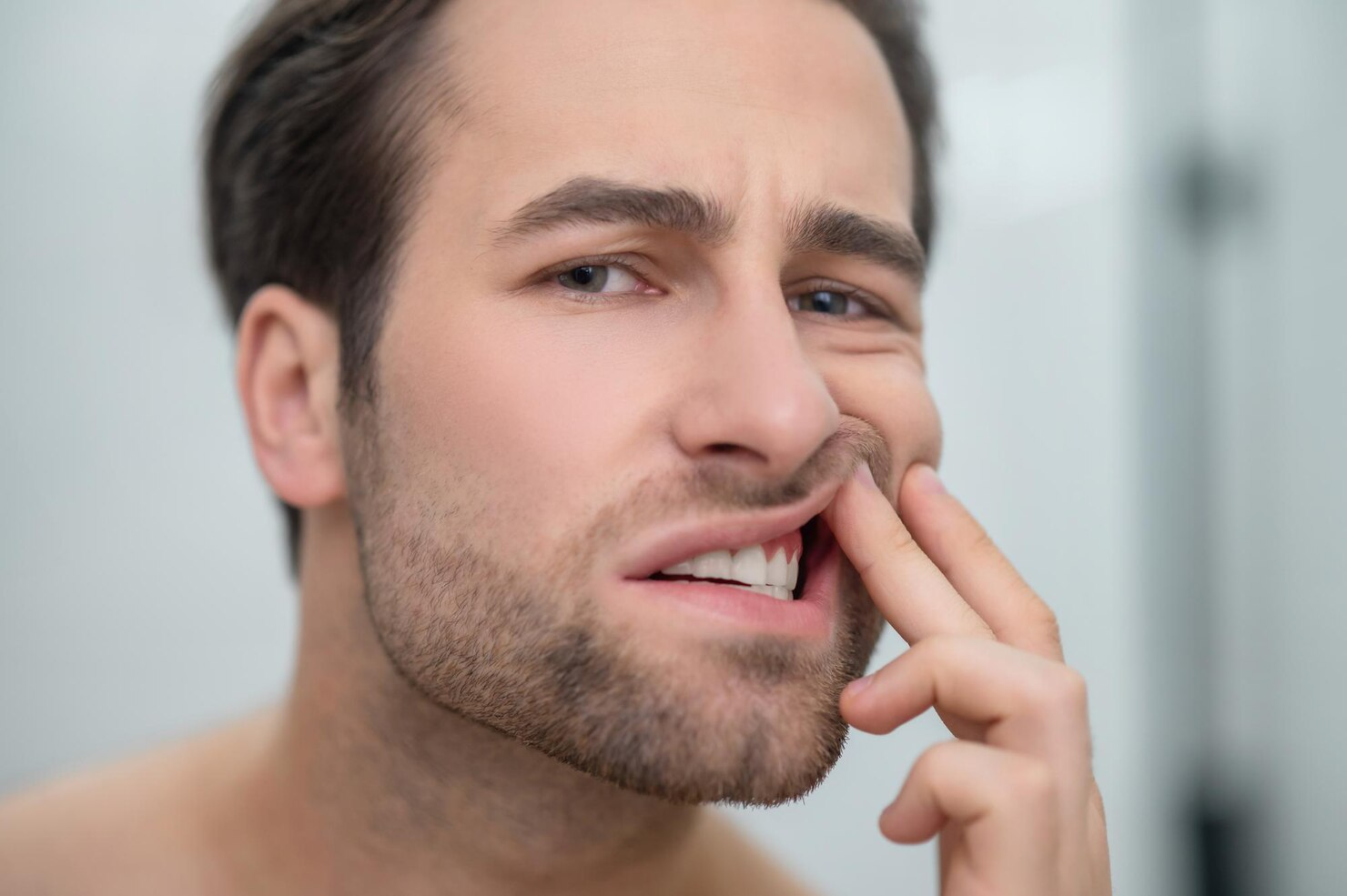 dental-problems-man-checking-his-teeth-looking-disturbed_259150-57888